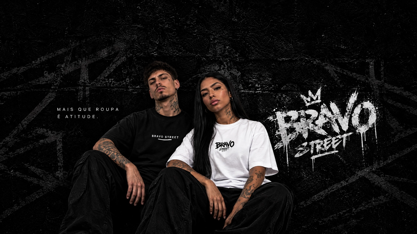 Um homem de camiseta preta Bravo Street e uma mulher de camiseta branca Bravo Street sentados diante de um muro com a pichação BRAVO STREET